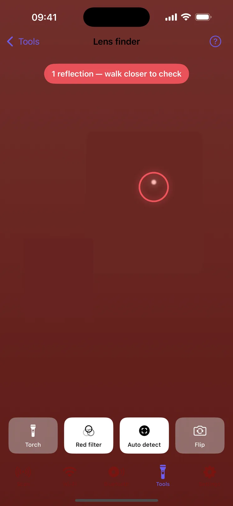 The lens finder in red-filter view with Auto detect on, circling one bright reflection under the banner “1 reflection — walk closer to check”, above the Torch, Red filter, Auto detect and Flip buttons
